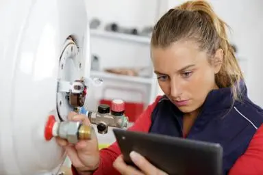 Trader looking at a mobile device while adjusting a valve