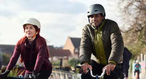 A man and woman on a cycle ride with helmets on