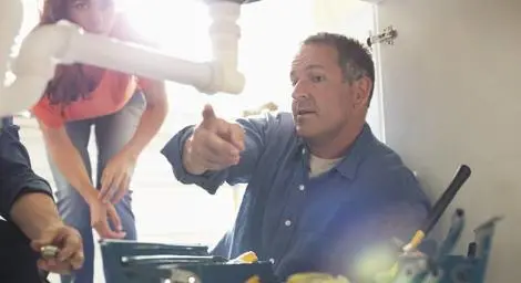 Plumber showing customer pipework under the sink