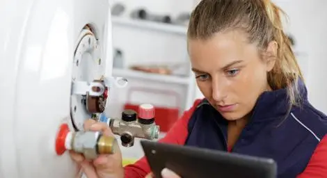 Trader looking at a mobile device while adjusting a valve