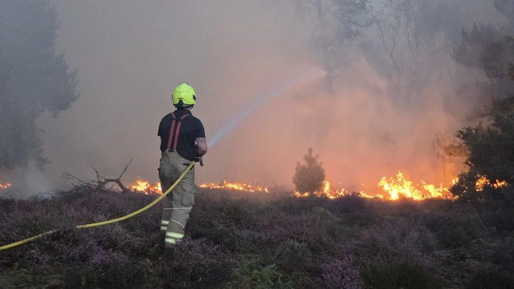 A firefighter tackling a wildfire on Dunwich Heath in Suffolk