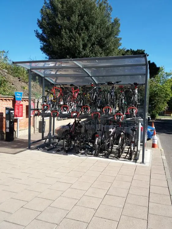A bicycle parking place, two rows of bicycles under a cover. Each row has space for 10 bikes. 