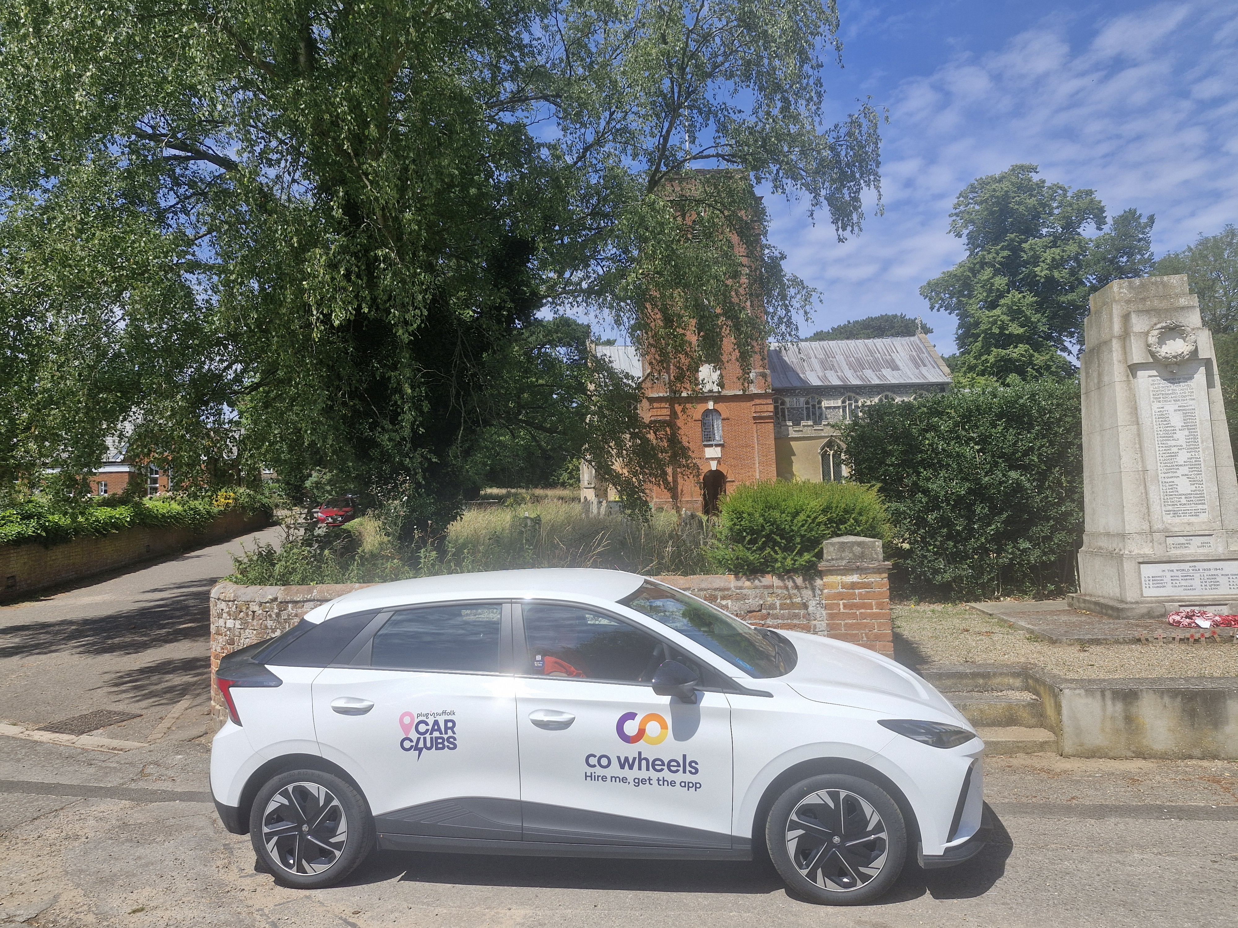 A car club vehicle at a church and war memorial.