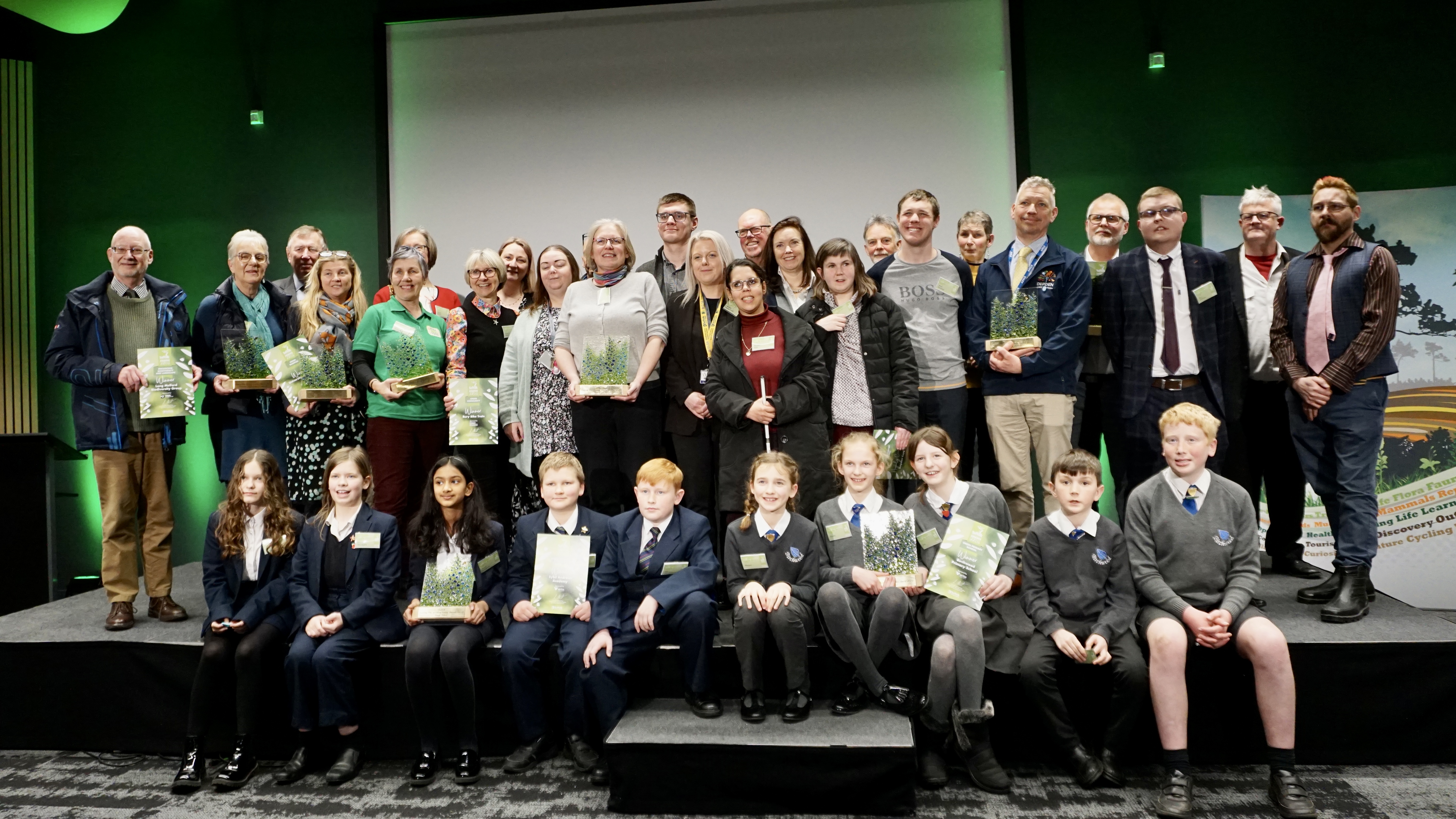 The group of winners from the 2023 Awards pose on stage