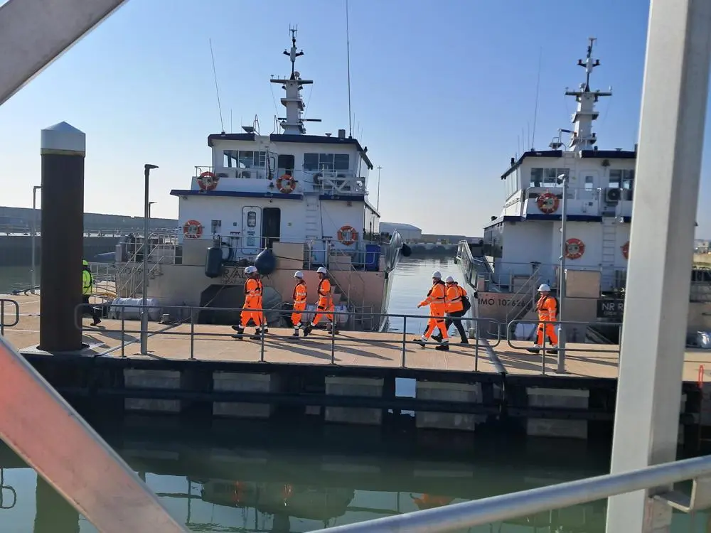 The cohort walking along the port in safety uniform