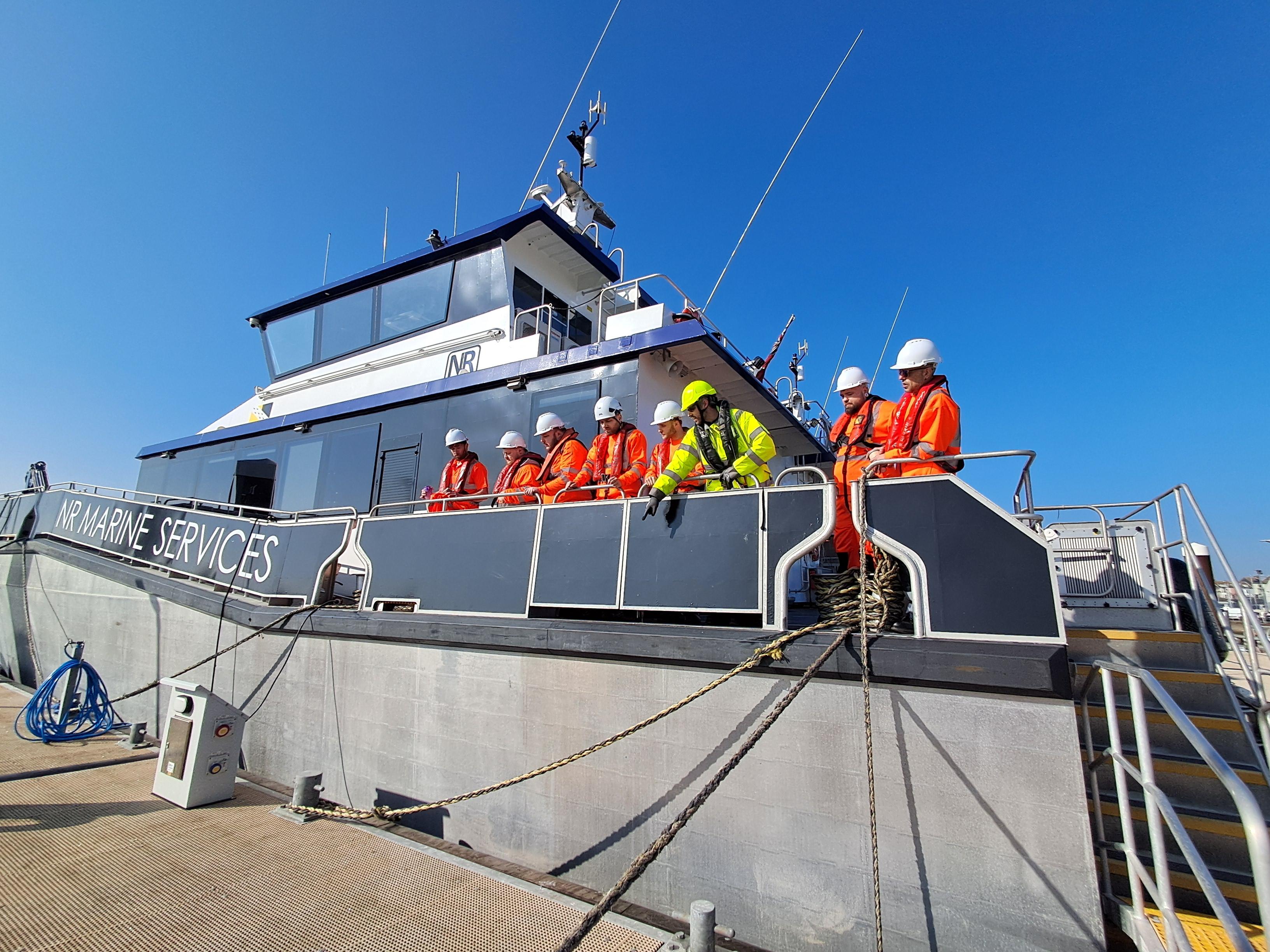 A group of 7 Skills Bootcamp Learners being instructed by a tutor on a vessel. 