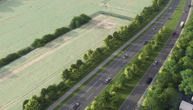Cars on a dual carriageway with green field in the background and trees.