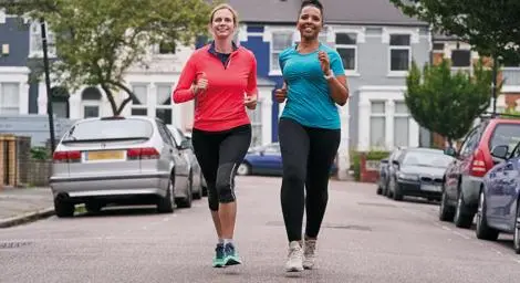 Two women going for a run on a street