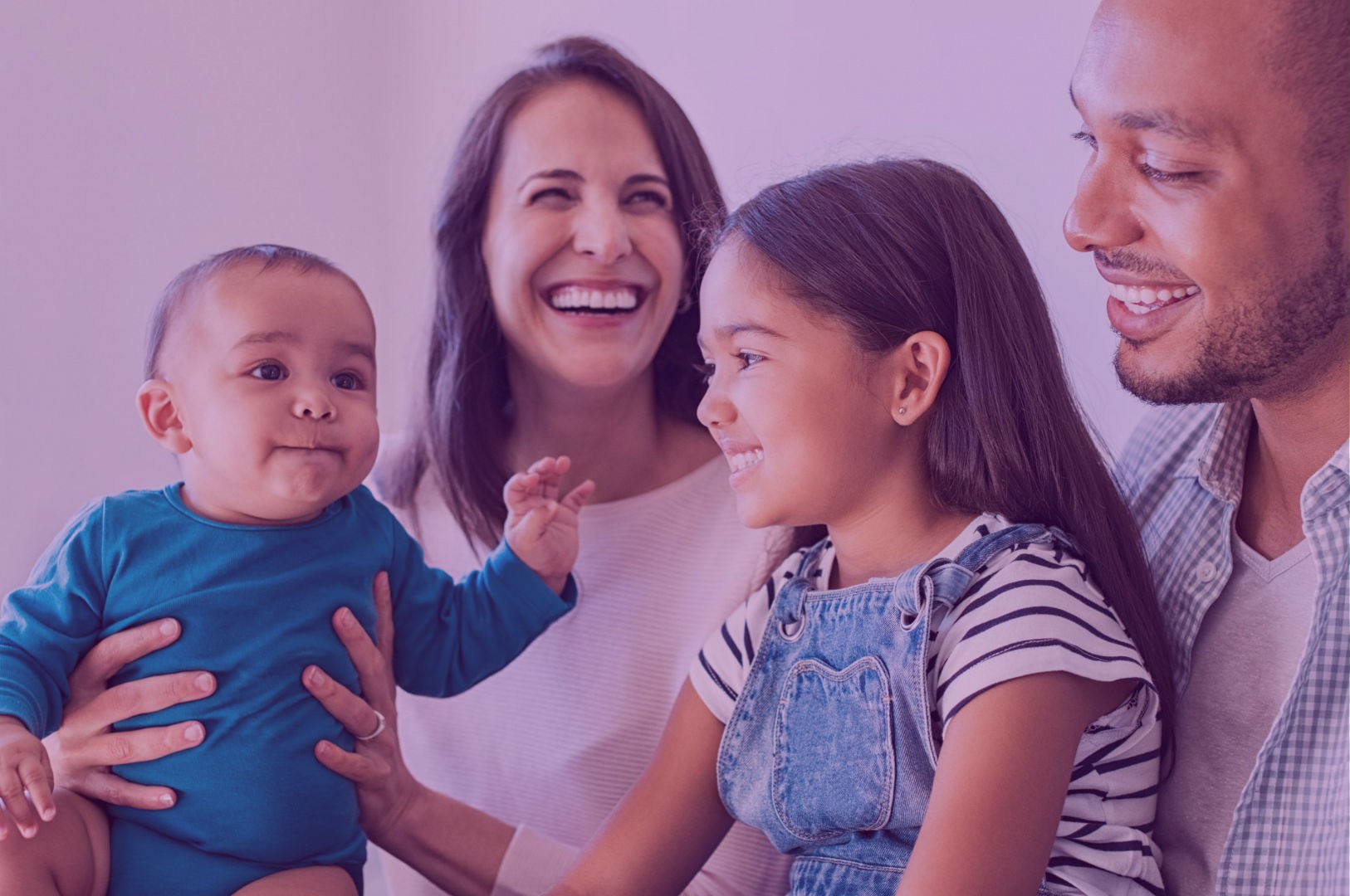 Happy family holding a baby and smiling