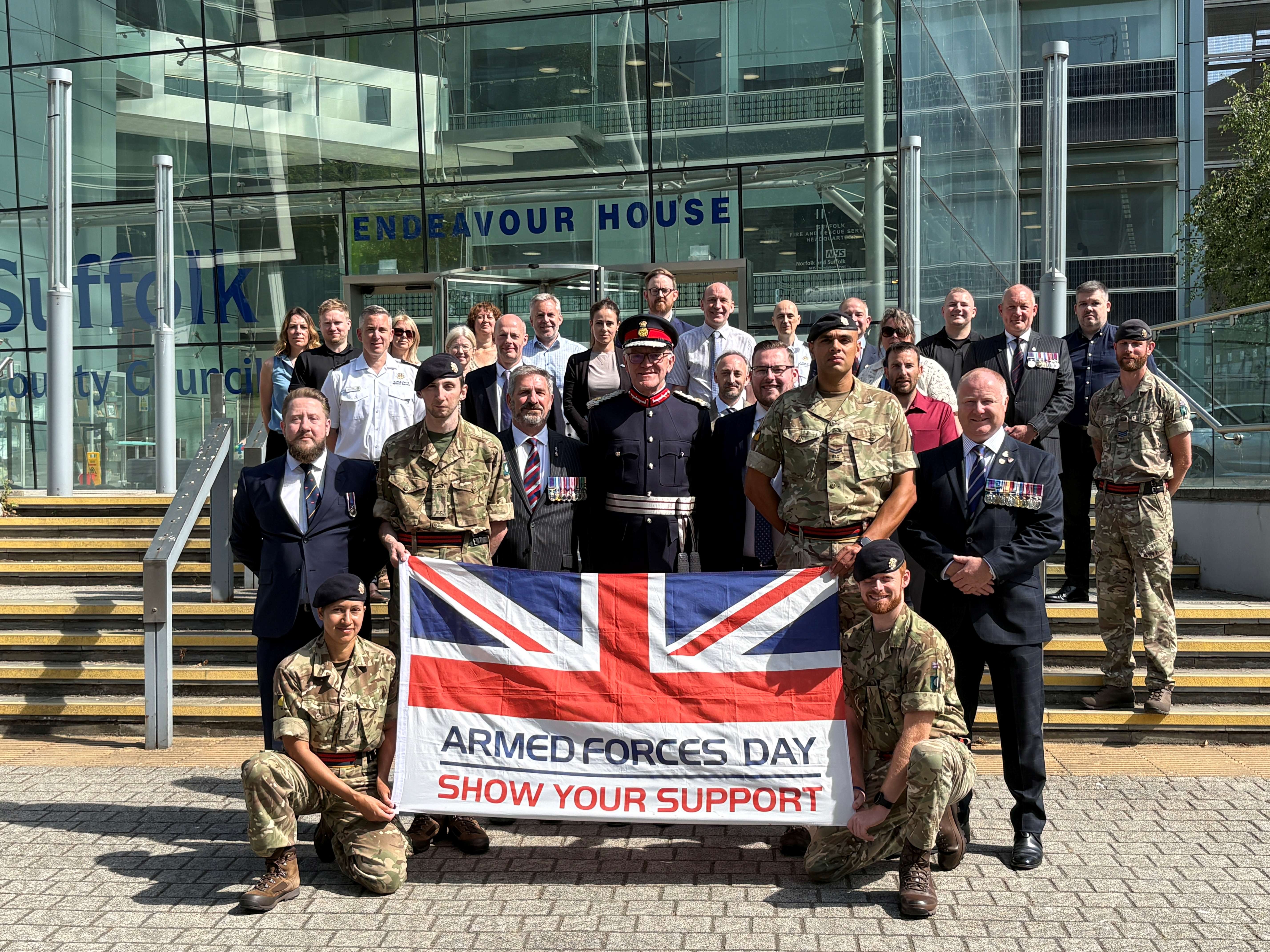 Soldiers and civilians holding the Armed Forces Day flag