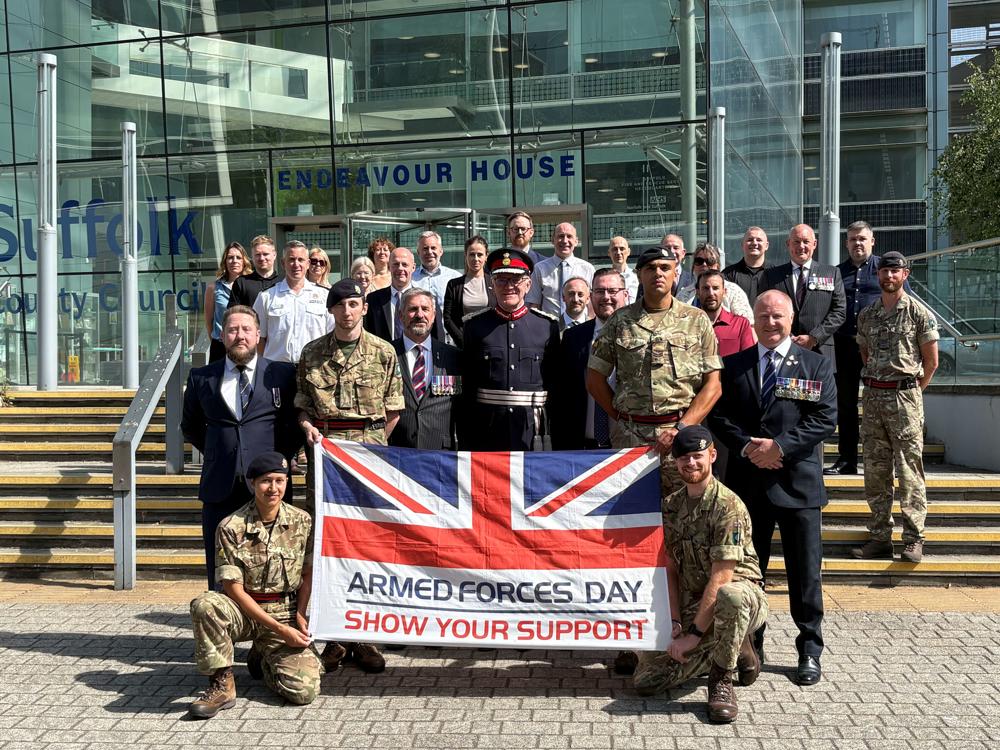 Soldiers and civilians holding the Armed Forces Day flag