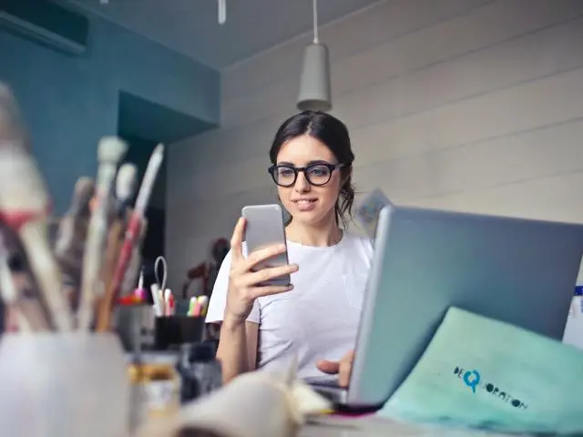 Art teacher using mobile phone and laptop