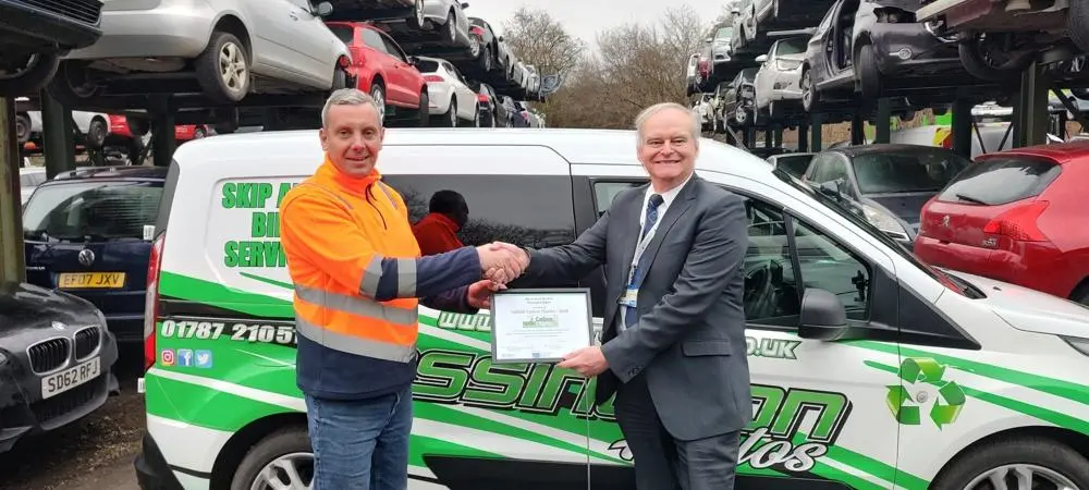 Frederick Cook is presented with the award by Peter Frost in the vehicle recycling yard