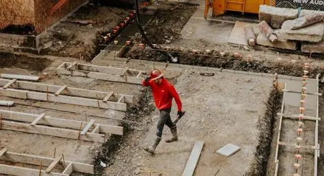 construction worker walking across an area of construction ground works