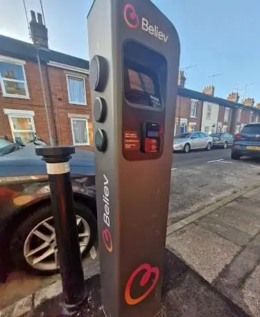 A Believ chargepoint. It is grey with Believ wrapping on it, and stands at 135cm tall.