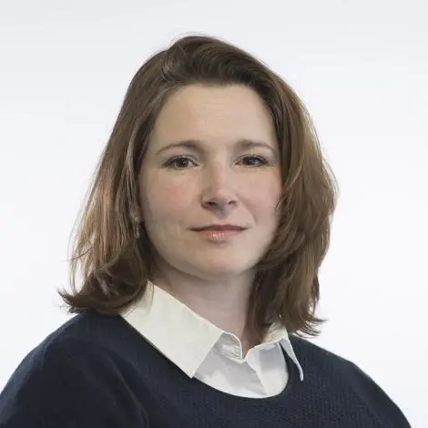 Image of Bobby Bennet - councillor, wearing a white blouse and blue jumper. Hair is cut short at the shoulder.