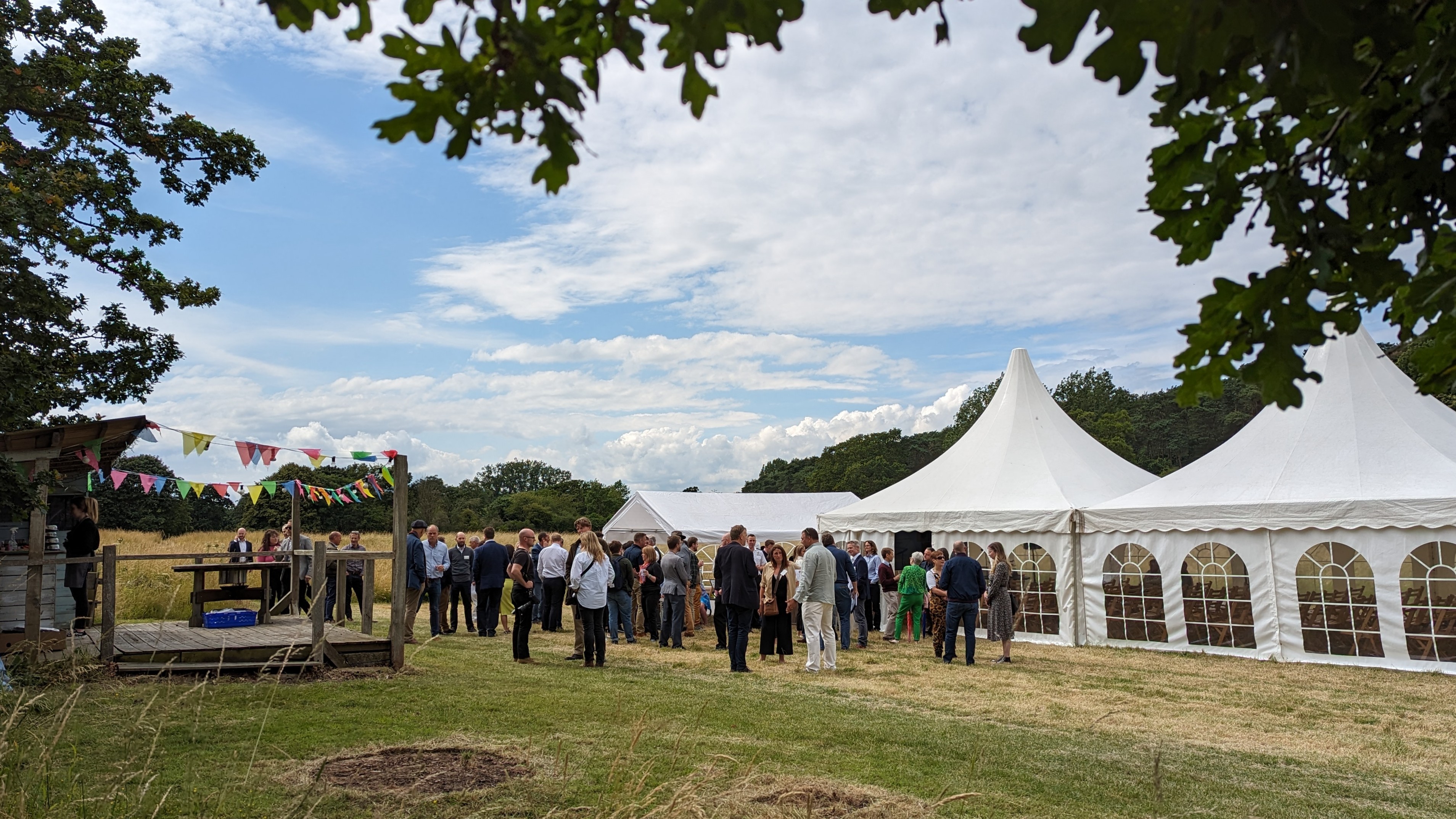 Guests network outside an event marquee in the sunshine