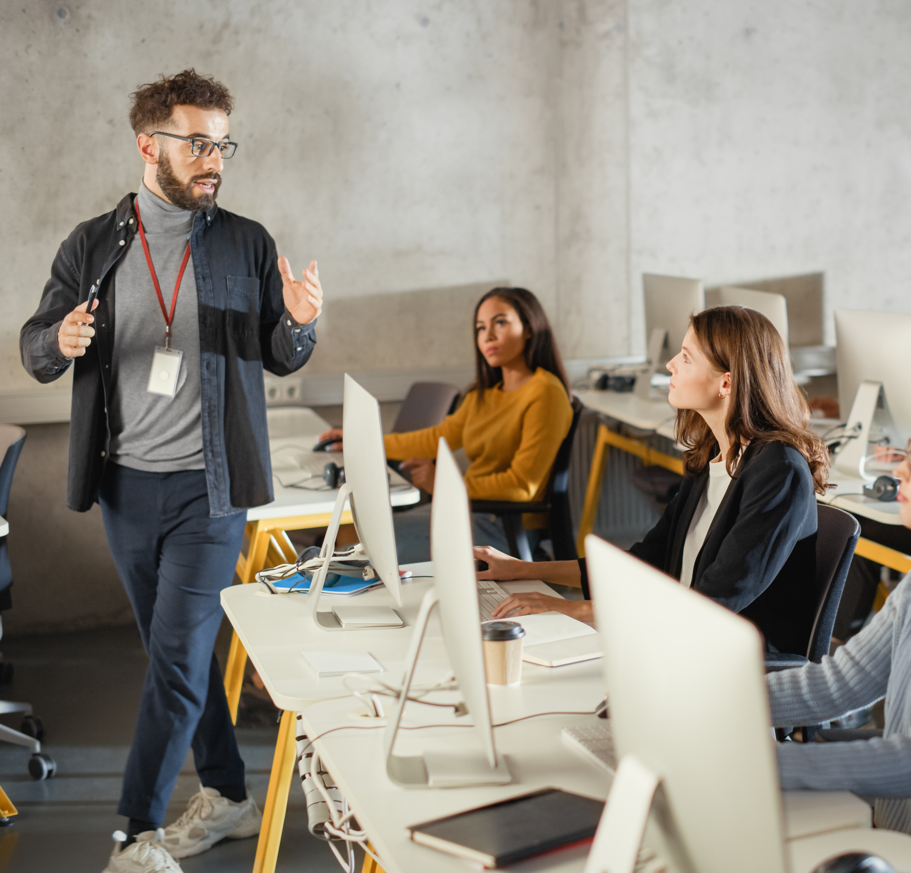 A teacher is working with two students who are using computers