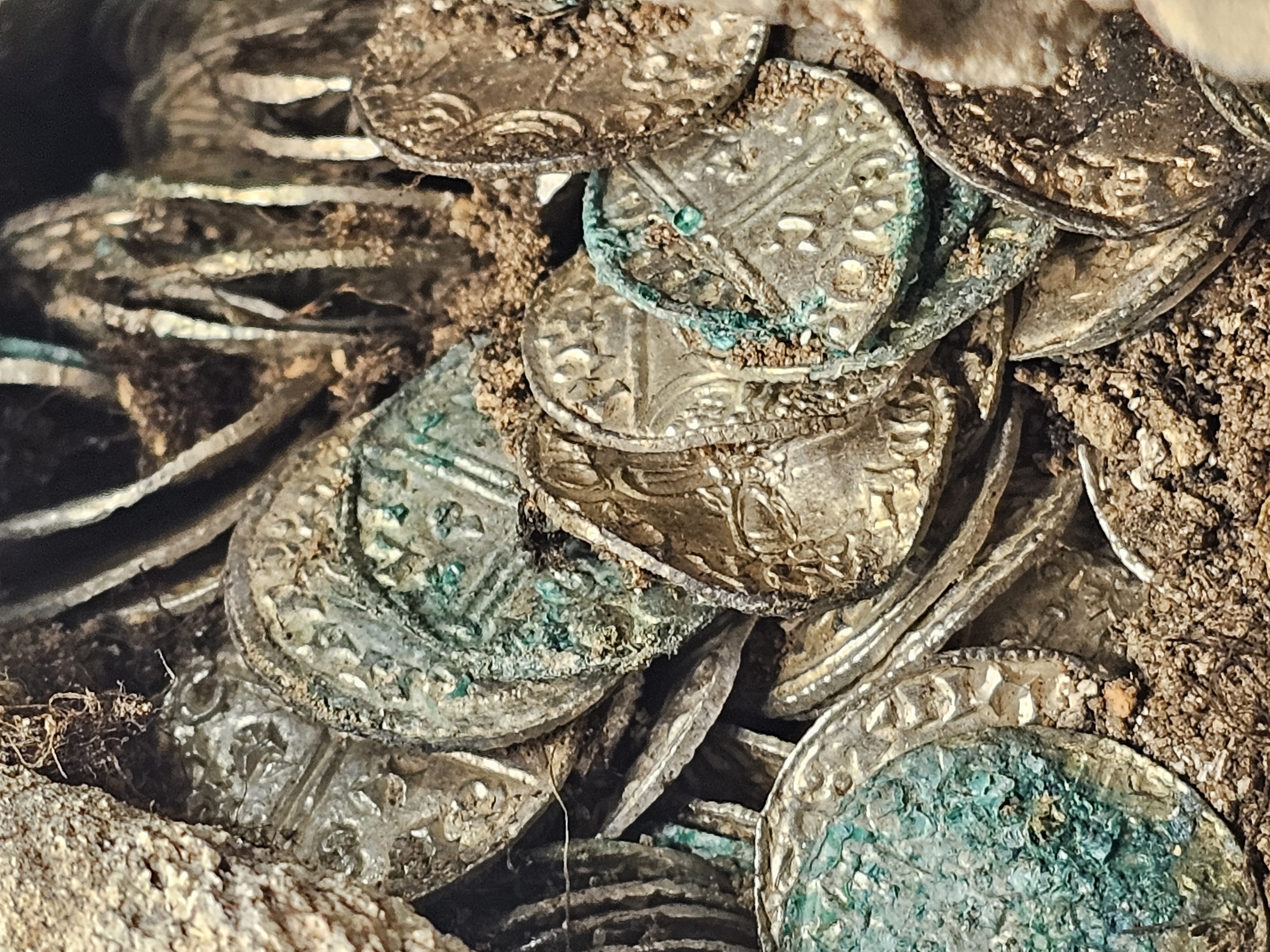 A close up photo of a pile of silver coins