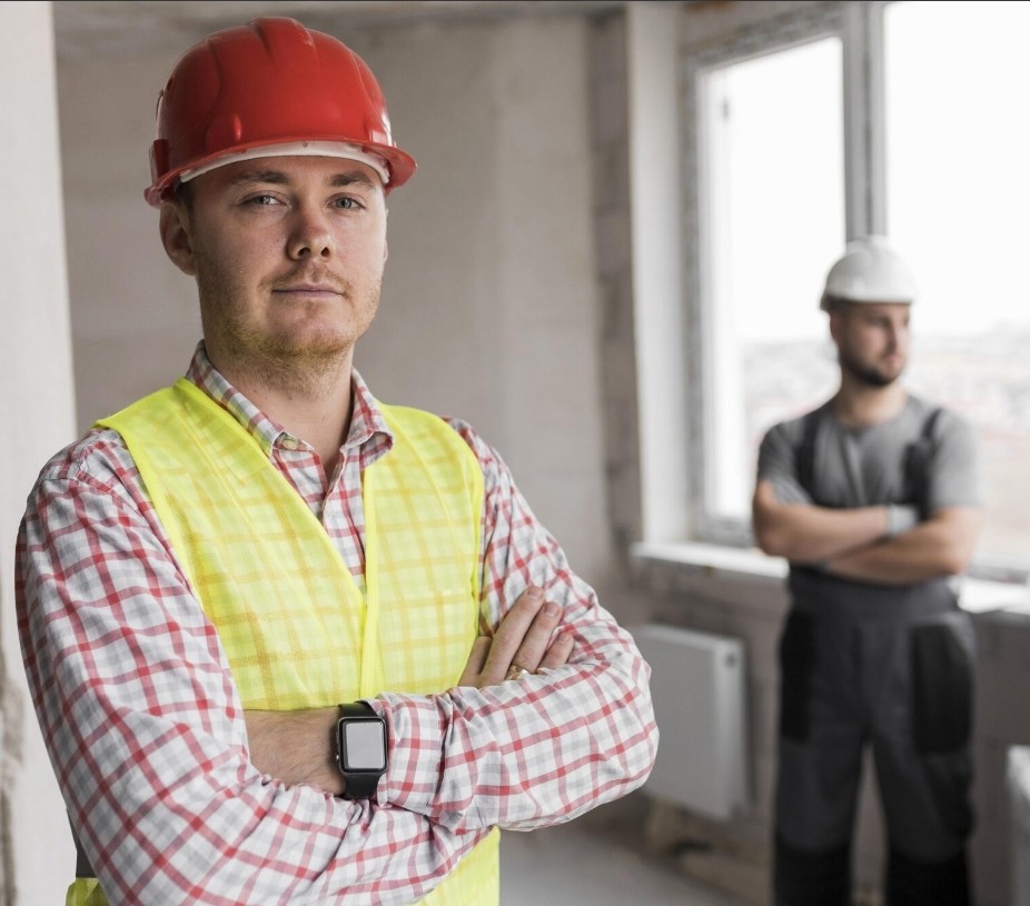 A construction worker is looking at us with his arms crossed