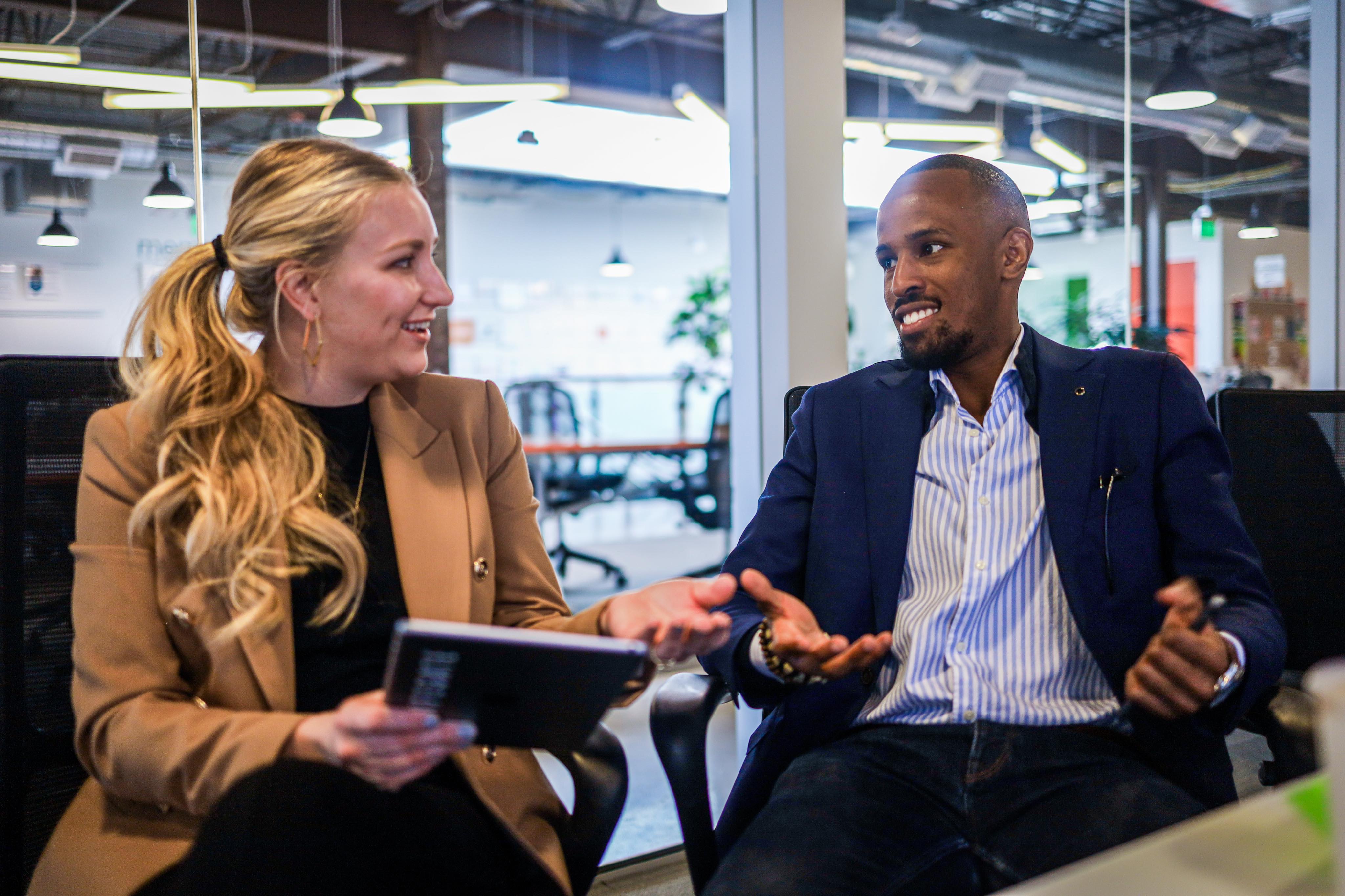 Business meeting between a man and woman holding a tablet