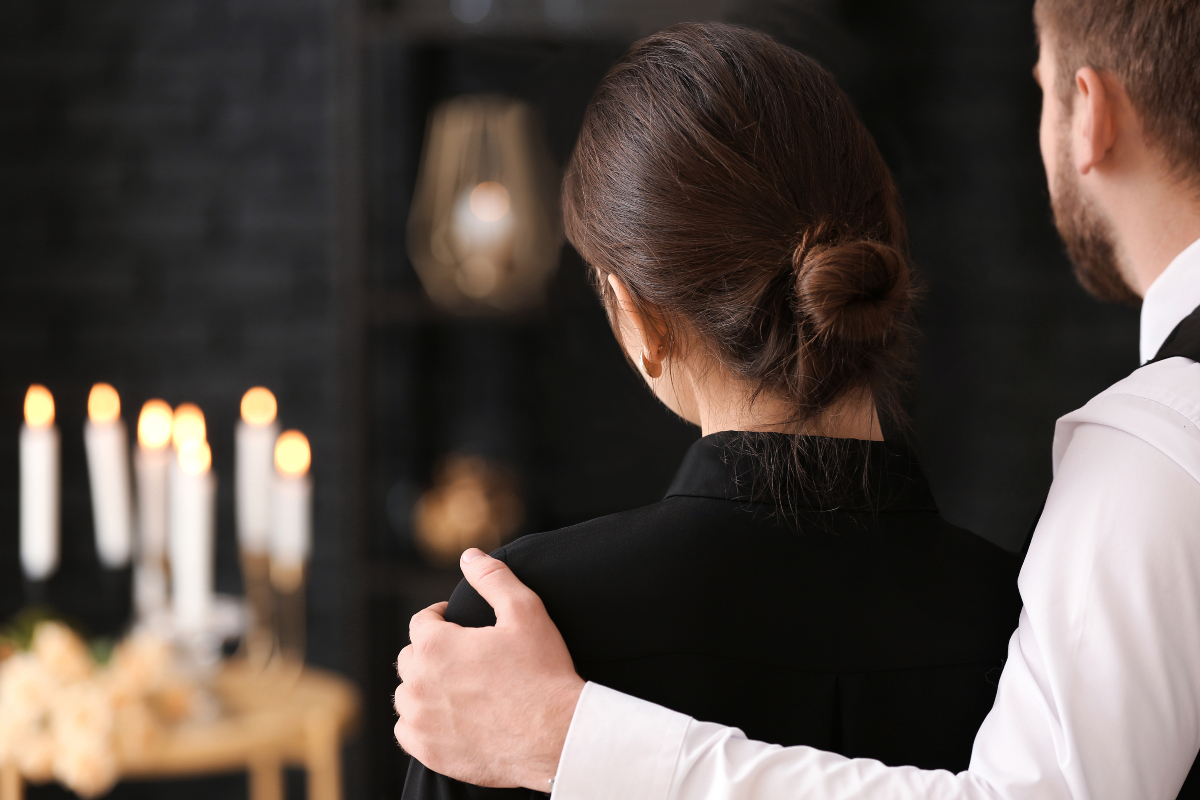 Man holding a woman at funeral