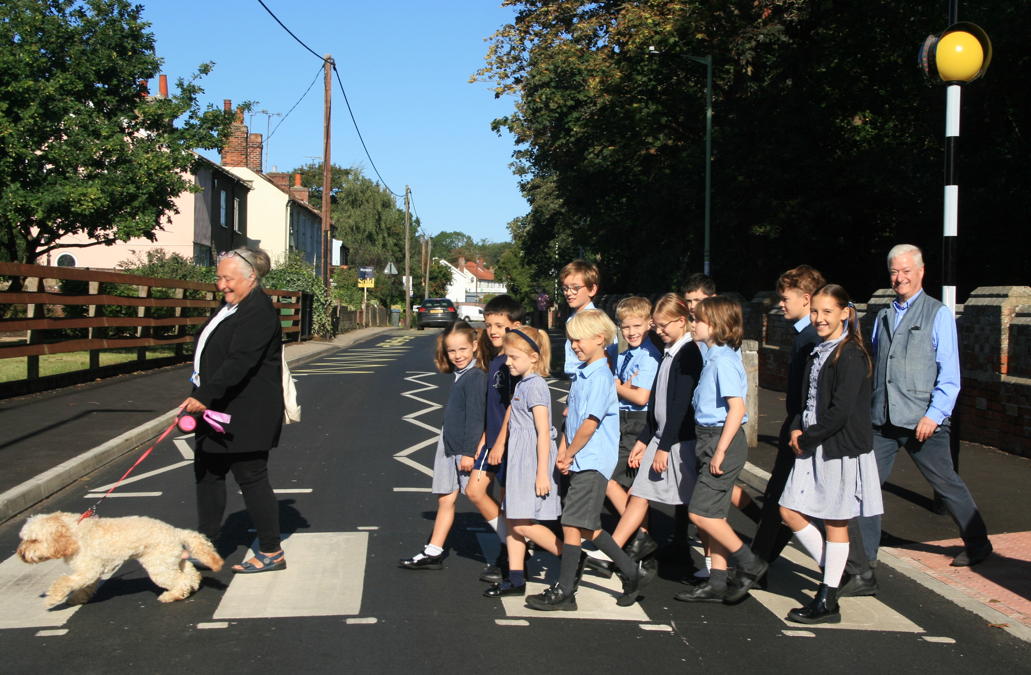 Adults, pupils and a dog on the new zebra crossing