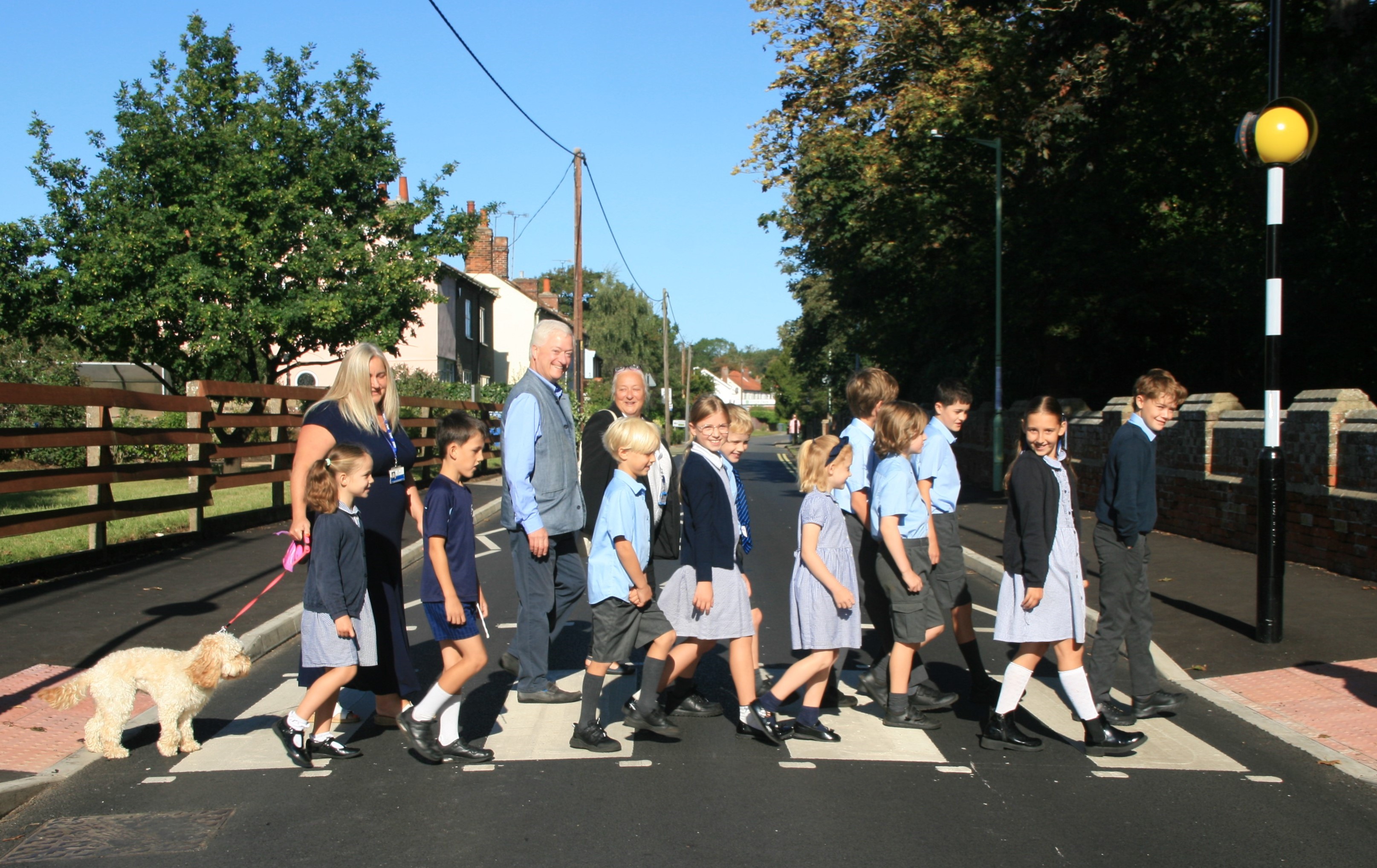 Children and adults with a dog on the zebra crossing