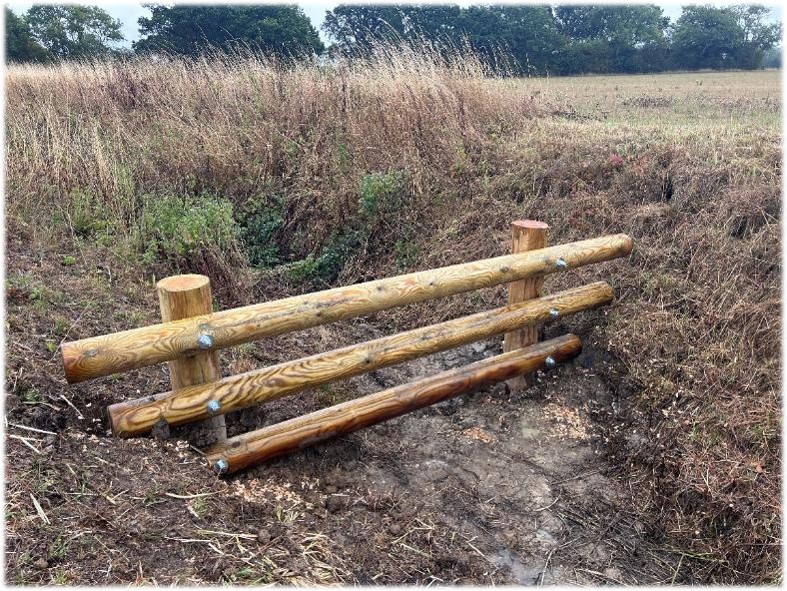 a leaky dam in a ditch by a field