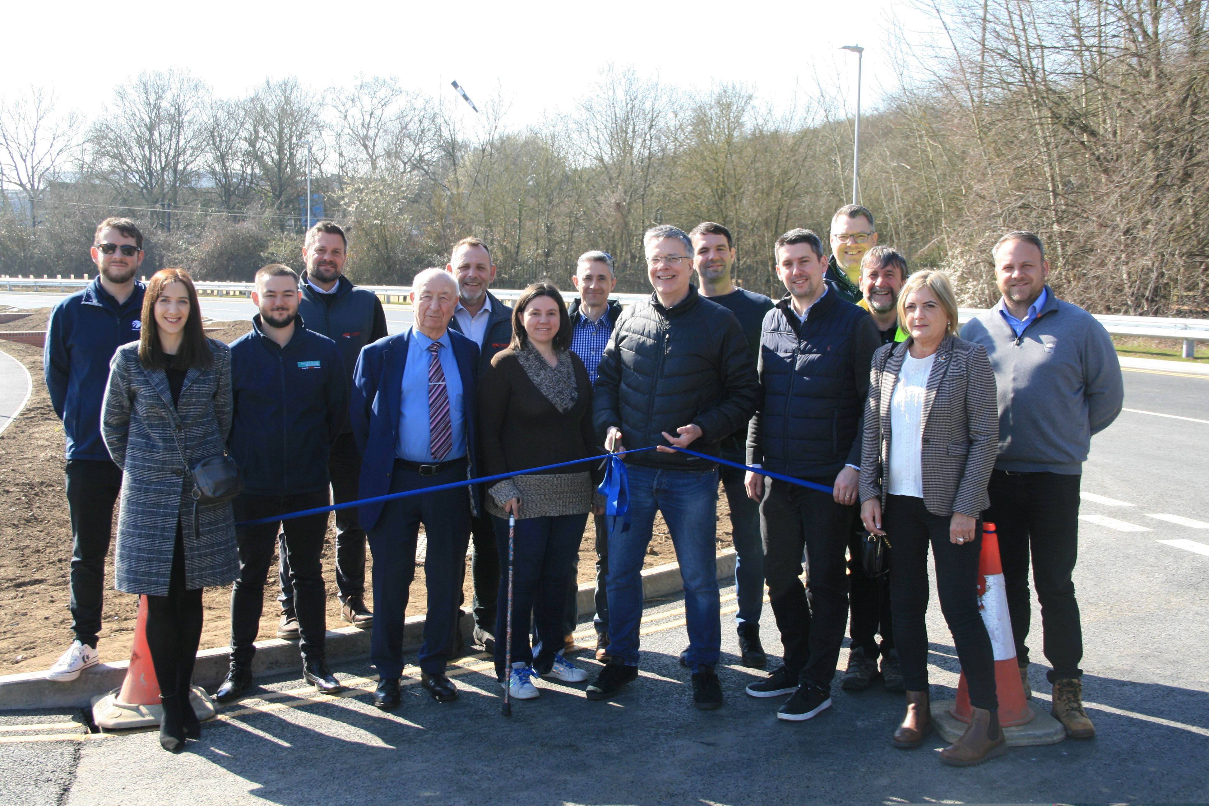 A crowd of people watch a blue ribbon being cut at Europa Way in Ipswich