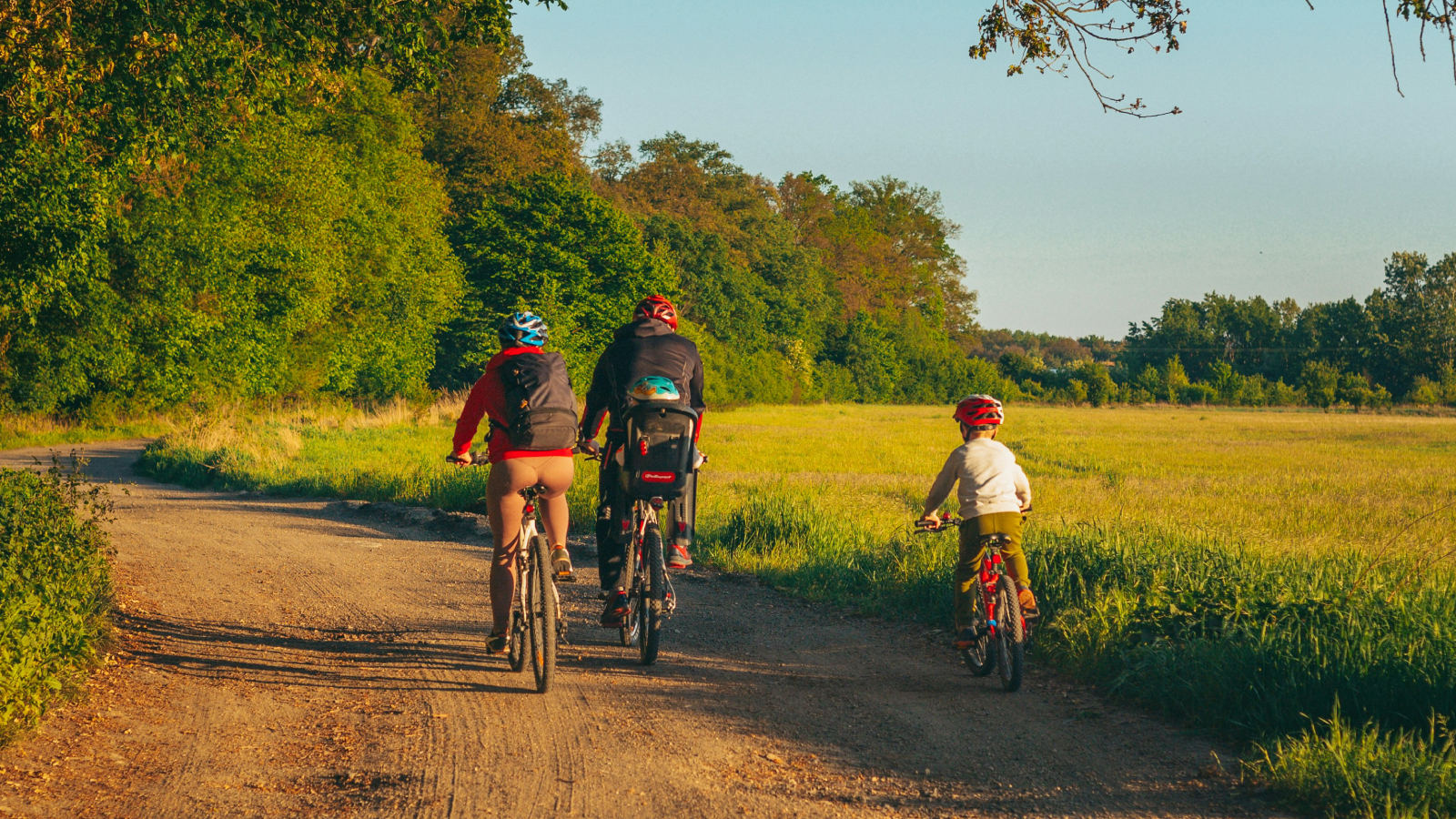 An image of a family cycling down a dirt road