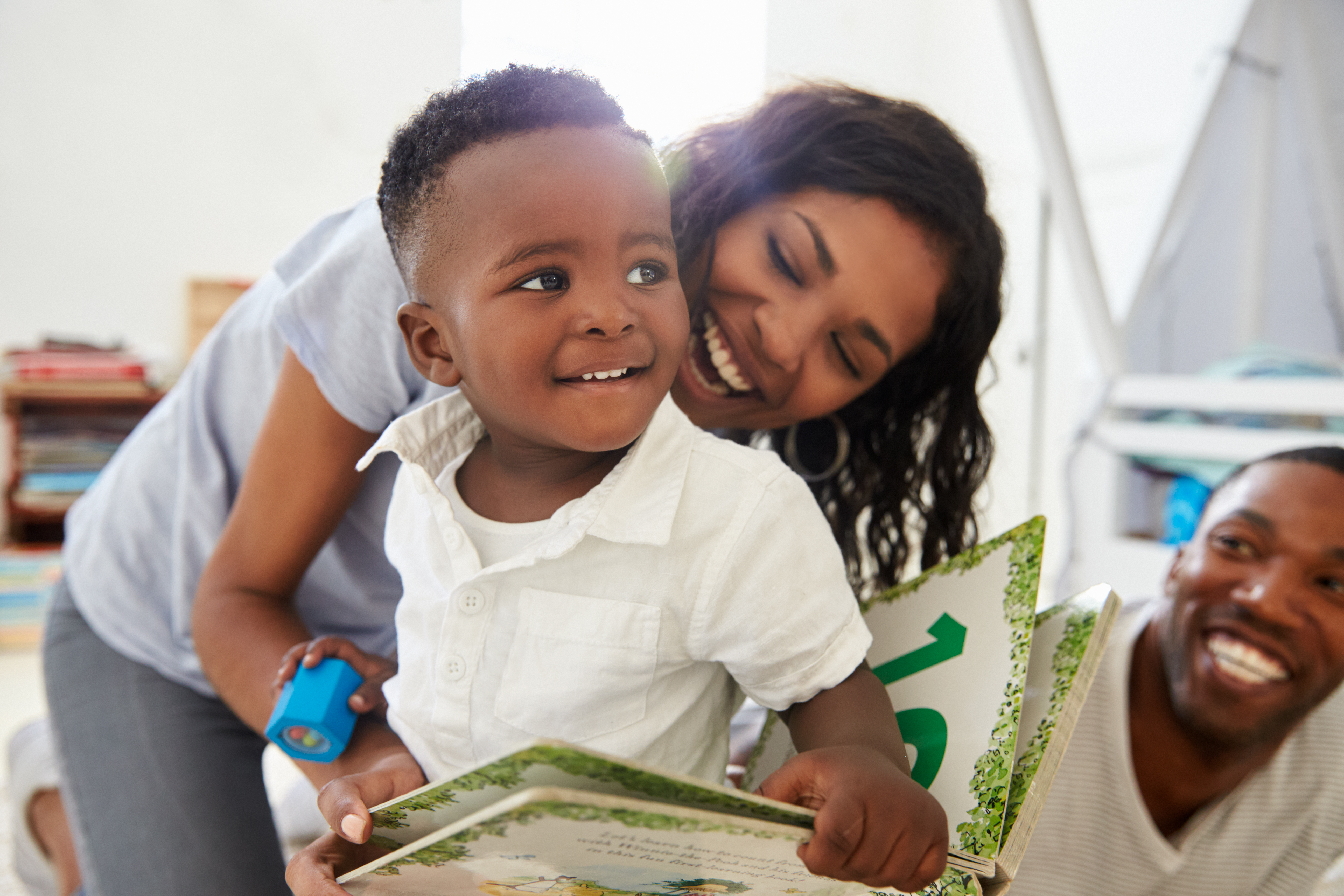 Young parents reading a book with their little boy