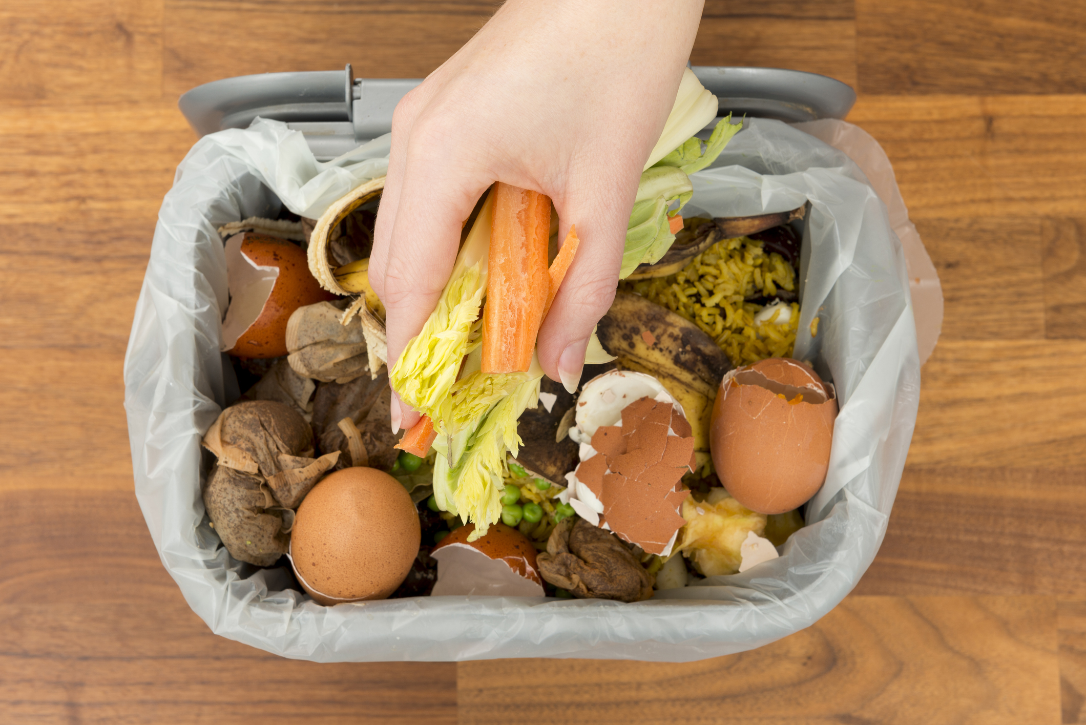 someone placing food waste into a container