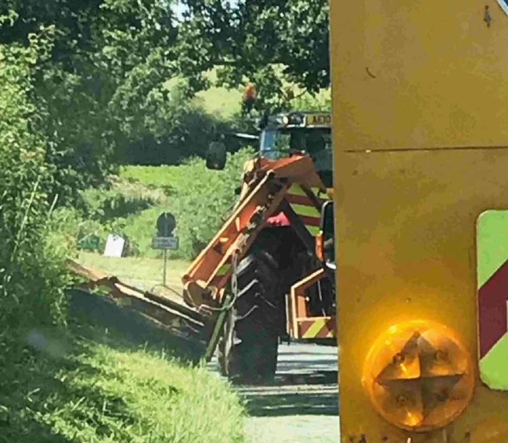A grass cutter mowing a verge
