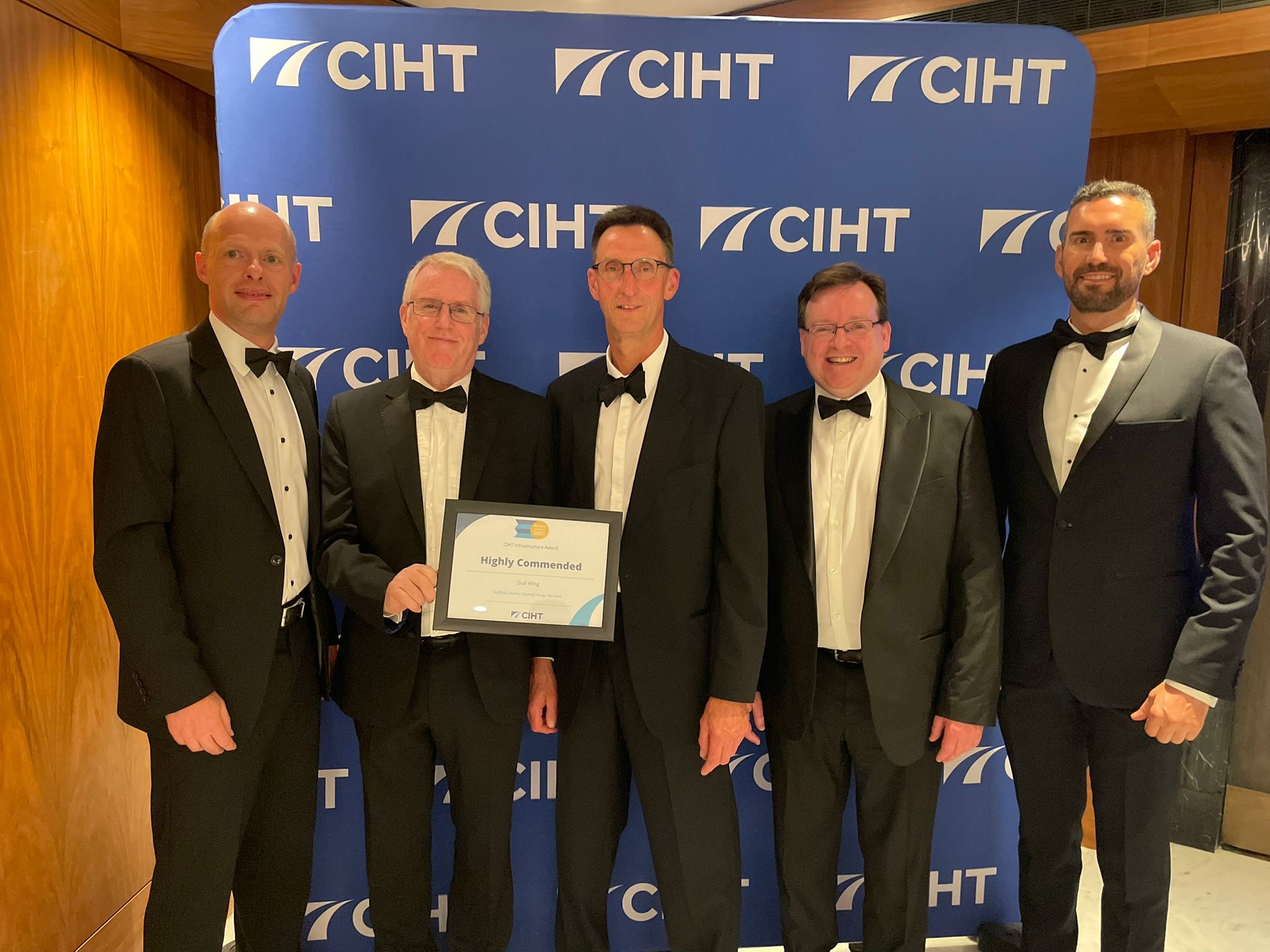 Five men in evening dress holding the Highly Commended certificate in front of a CIHT backdrop.