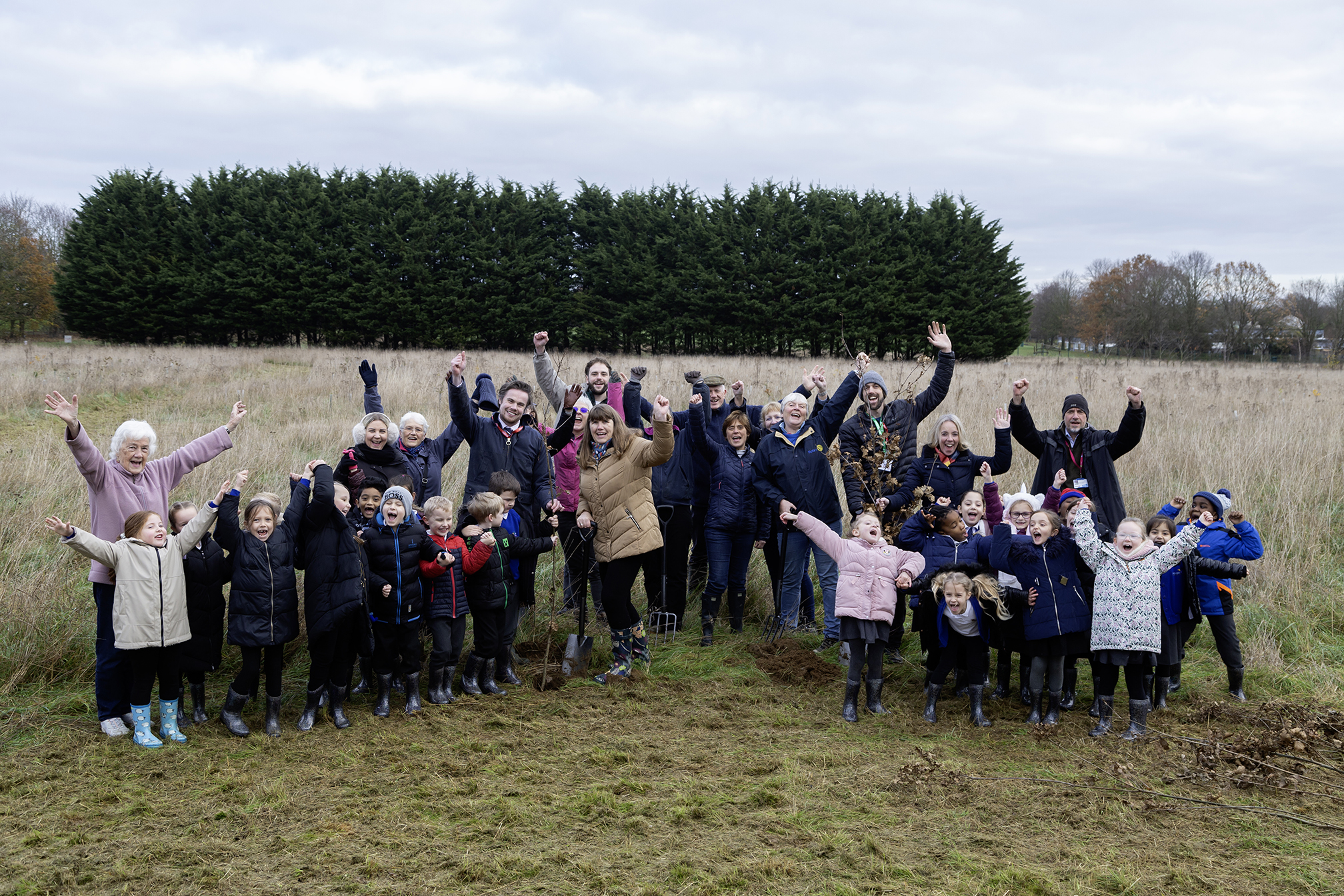 Children, staff, community members, volunteers and councillors celebrate planting trees