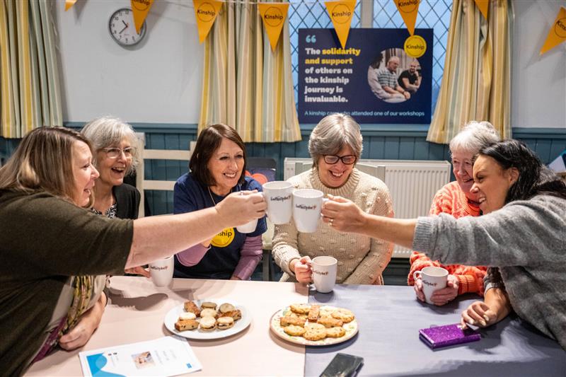 A group of Kinship carers enjoying tea and biscuits
