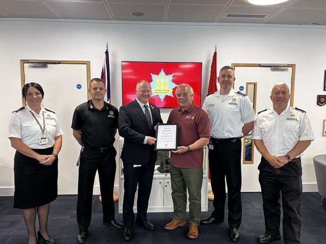 Project lead from Mid Suffolk Rotary Peter Andrews presented Suffolk Fire and Rescue Service with a framed certificate to mark the milestone of £100,000 raised (from L-R: Area Manager for Prevention and Protection, Allie O'Neill, Chief Fire Officer Jon Lacey, Suffolk County Council Cabinet Member for Devolution, Planning and the Fire Service, Councillor Tristan Gale, Peter Andrews, Deputy Chief Fire Officer Henry Griffin and Prevention Manager Mel Buck.)