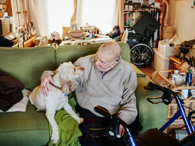 Man sitting on his sofa with his dog
