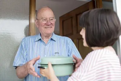 Older man receiving a prepared meal at home