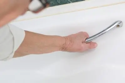 Older woman gripping bath handle
