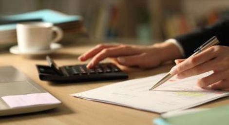 Woman using calculator and taking notes