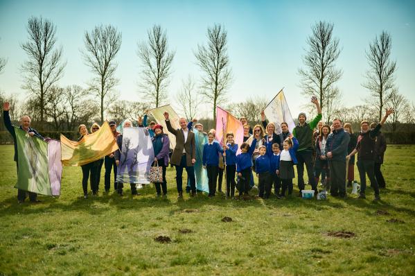 Teachers and Students at Howard Academy wave in front of newly planet trees.