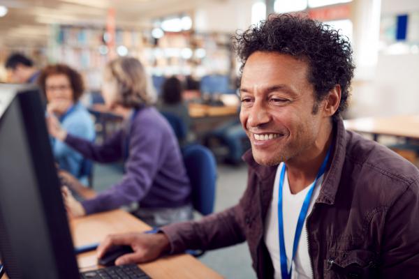 Man using computer wearing a landyard