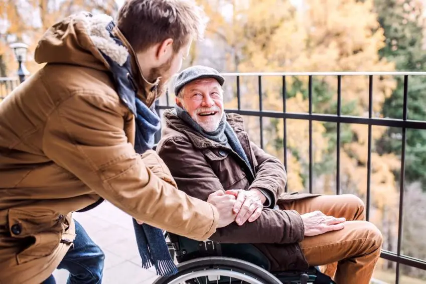 Man caring for older man in wheelchair