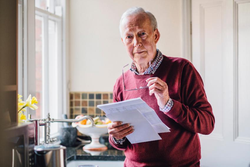 Older man holding bills
