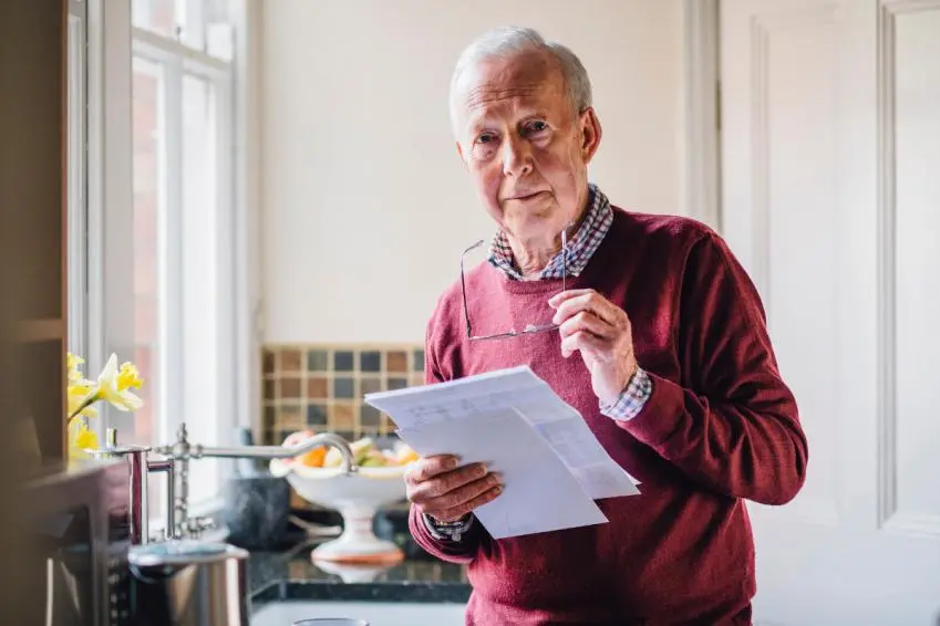 Older man holding bills