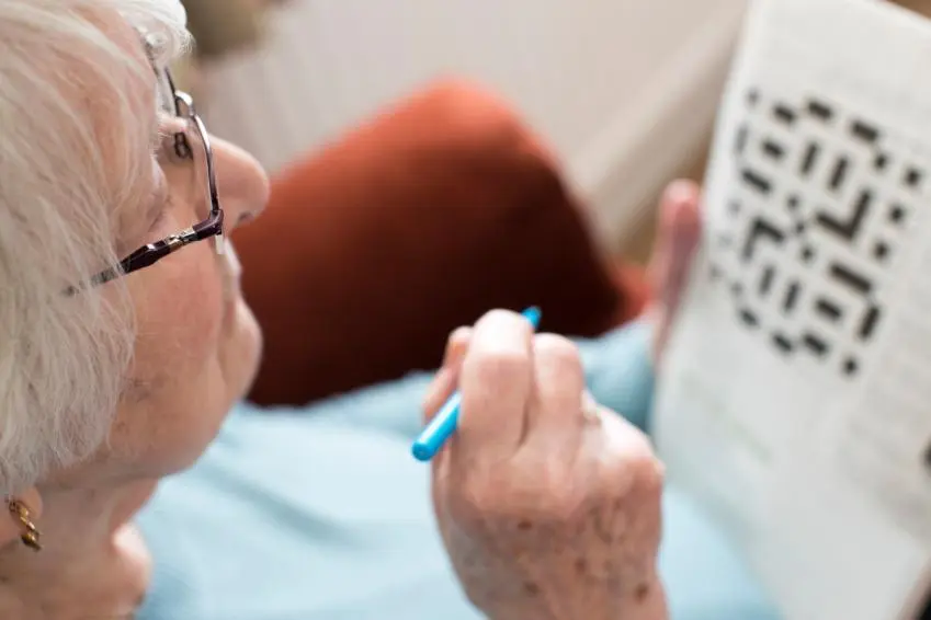 Older woman doing crossword puzzle