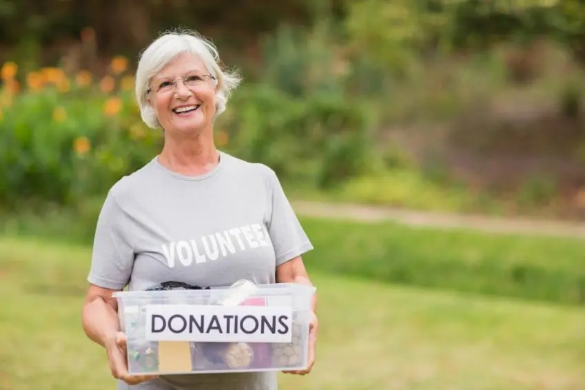 Older woman volunteer with donations box