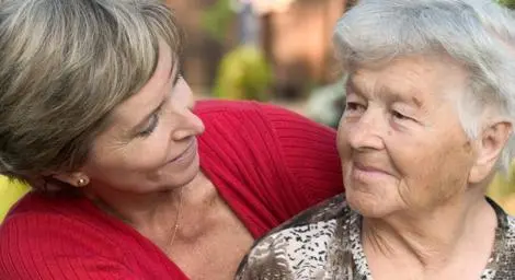 Younger woman looking affectionately at older woman